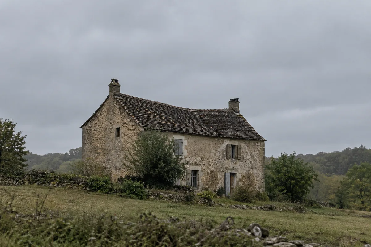 Ligne de faîtage légèrement affaissée sur une vieille maison sous un ciel gris